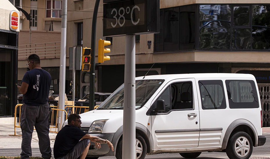 Dos hombres se refugian del calor a la sombra (EFE).